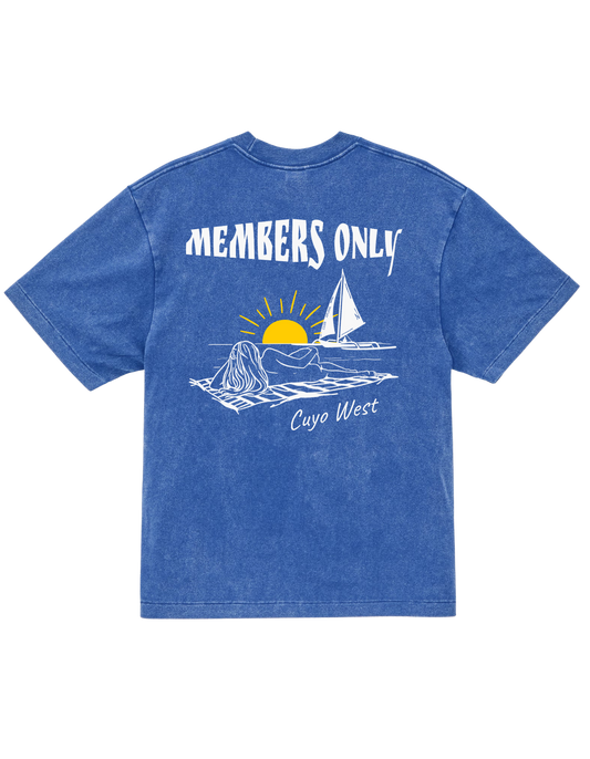 Back of a blue Members Only Cuyo West T-shirt with a golden sunset and sailboat graphic.